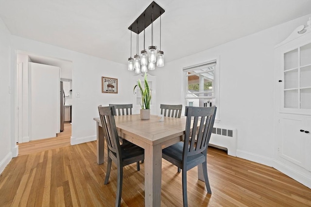 359 Corey St, Boston, MA 02132 - dining space with radiator, light wood-style floors, and baseboards