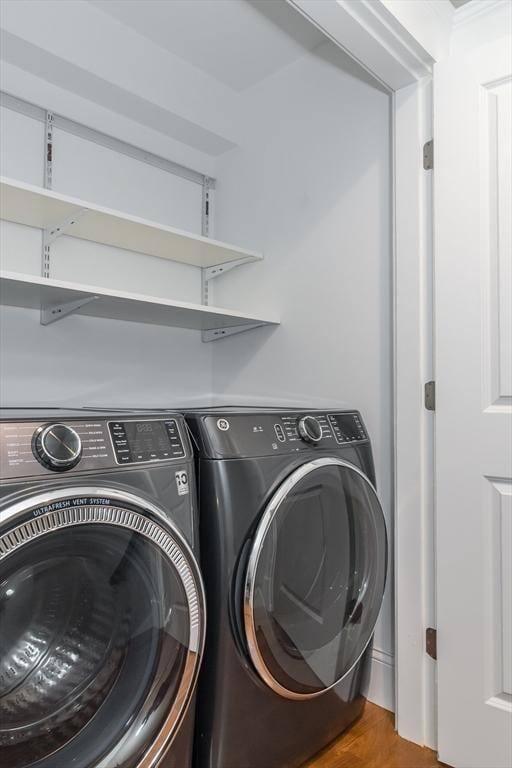 laundry area with laundry area, independent washer and dryer, and wood finished floors