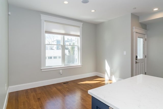 kitchen featuring visible vents, light stone counters, wood finished floors, recessed lighting, and baseboards