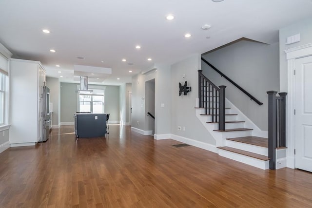 unfurnished living room featuring recessed lighting, baseboards, and dark wood-type flooring