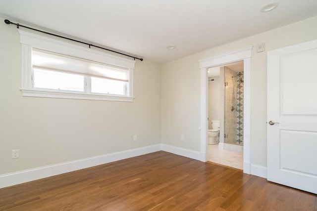 empty room featuring baseboards and wood finished floors