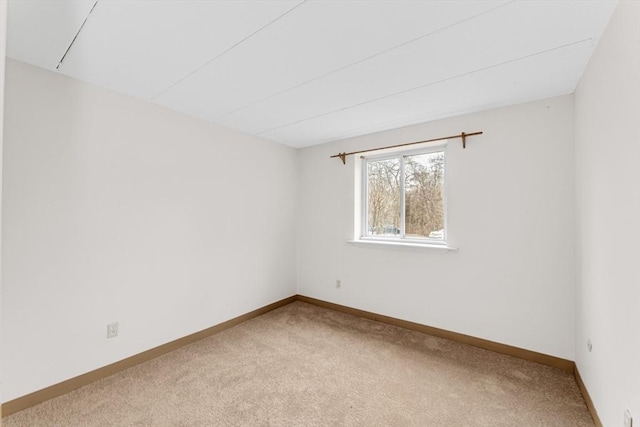 carpeted spare room with baseboards