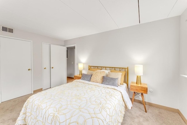 carpeted bedroom featuring visible vents and baseboards