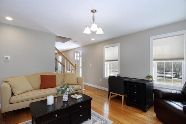 living room with a notable chandelier and light hardwood / wood-style flooring