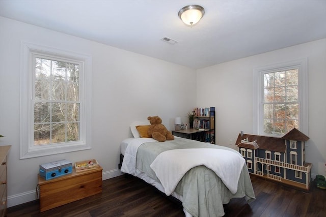 bedroom with multiple windows and dark wood-type flooring