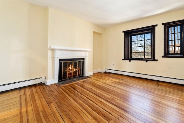 unfurnished living room with light hardwood / wood-style floors and baseboard heating