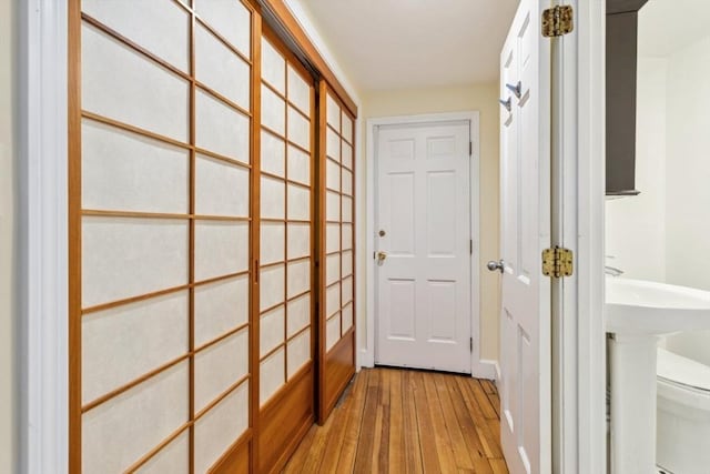 doorway with light wood-type flooring and sink