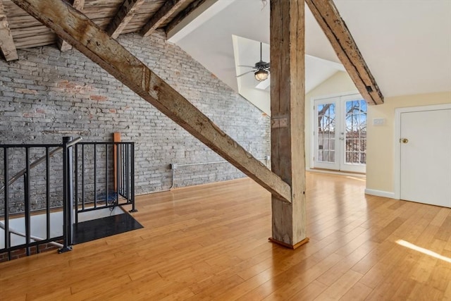 bonus room featuring brick wall, hardwood / wood-style flooring, vaulted ceiling with beams, and ceiling fan