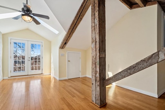 additional living space with ceiling fan, lofted ceiling with skylight, and light hardwood / wood-style floors