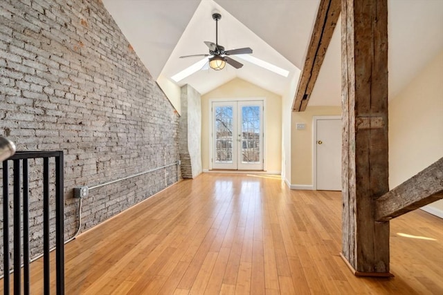 bonus room with light wood-type flooring, french doors, ceiling fan, and lofted ceiling with skylight