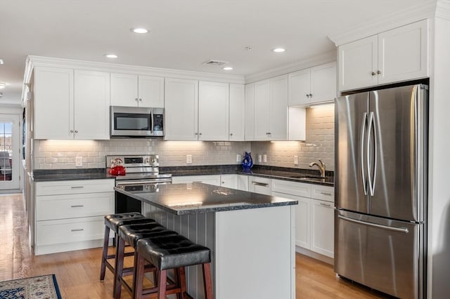 kitchen featuring stainless steel appliances, a sink, and white cabinets