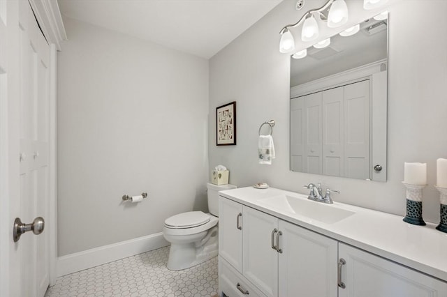 bathroom featuring a closet, baseboards, vanity, and toilet