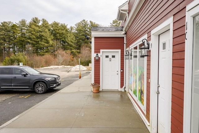 entrance to property with a shingled roof