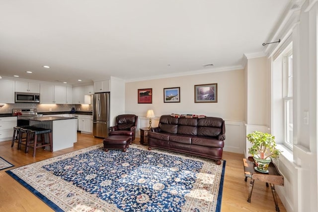 living area featuring recessed lighting, light wood-type flooring, visible vents, and crown molding