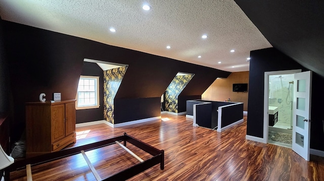 interior space with a textured ceiling, lofted ceiling, and hardwood / wood-style flooring