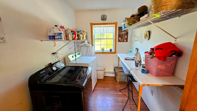 clothes washing area with a textured ceiling, dark hardwood / wood-style floors, washing machine and clothes dryer, and a baseboard radiator