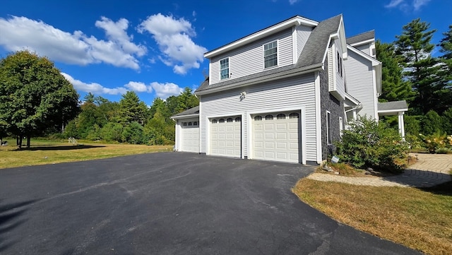 view of side of property featuring a lawn and a garage