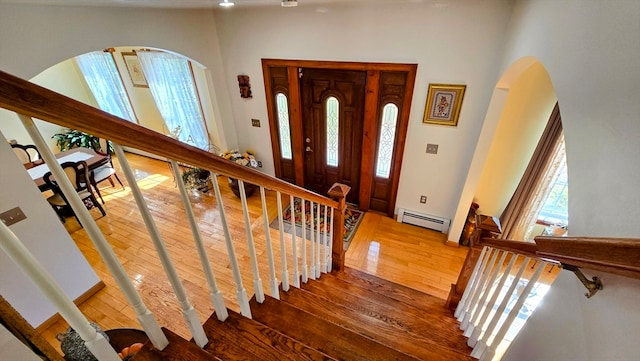 entrance foyer featuring a baseboard heating unit and wood-type flooring