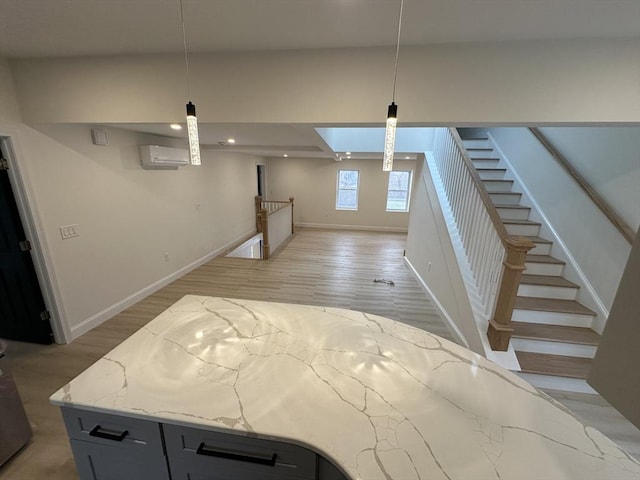 basement featuring light hardwood / wood-style floors and a wall mounted AC