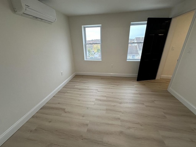 empty room featuring light hardwood / wood-style flooring and a wall unit AC