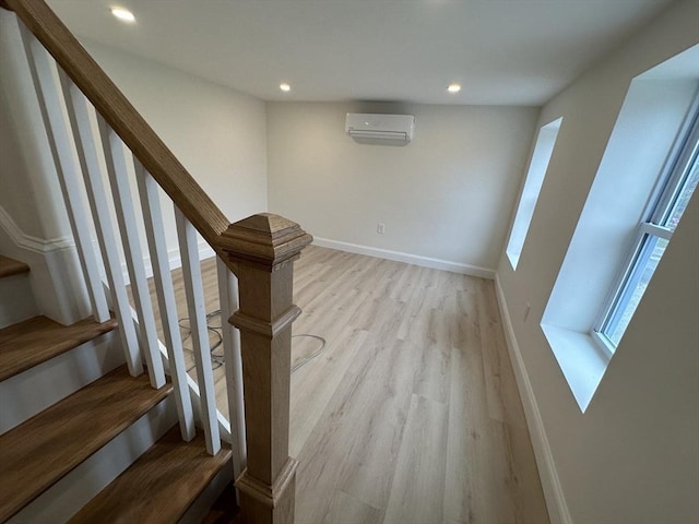 stairway featuring a wall mounted air conditioner and wood-type flooring