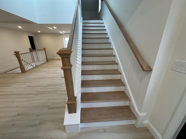 staircase with hardwood / wood-style flooring and a skylight