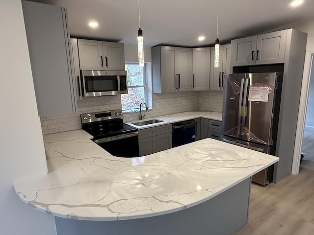 kitchen with gray cabinetry, decorative light fixtures, and appliances with stainless steel finishes