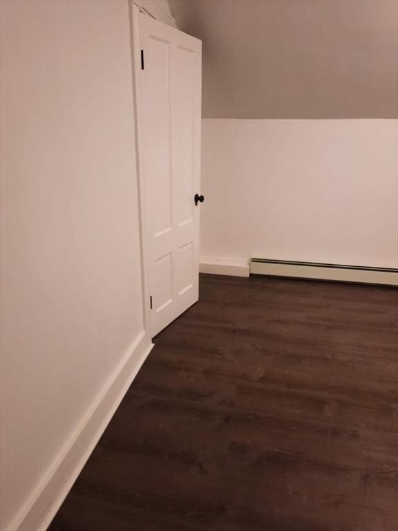 hall with a baseboard radiator and dark hardwood / wood-style floors