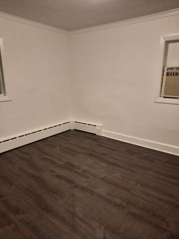 spare room featuring cooling unit, crown molding, dark wood-type flooring, and baseboard heating