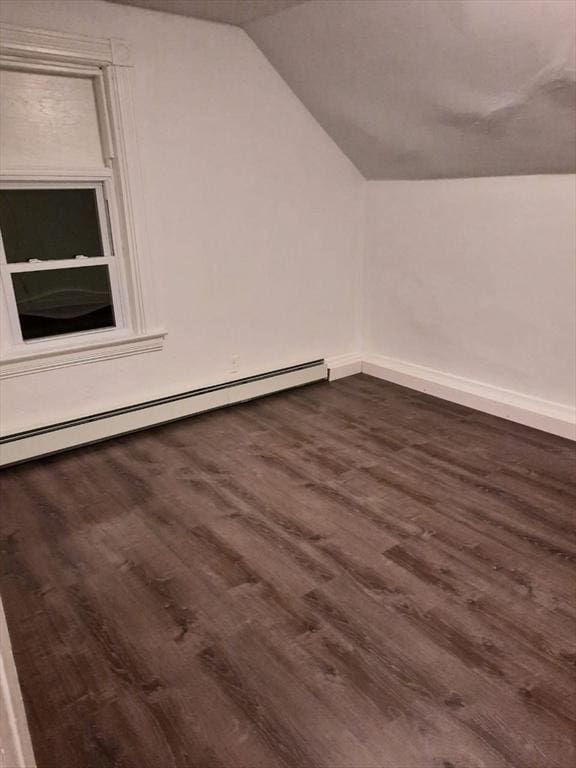 bonus room featuring dark wood-type flooring, vaulted ceiling, and a baseboard heating unit