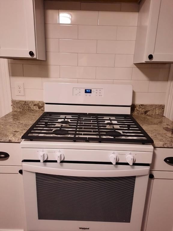 interior details featuring decorative backsplash, light stone countertops, gas range gas stove, and white cabinets