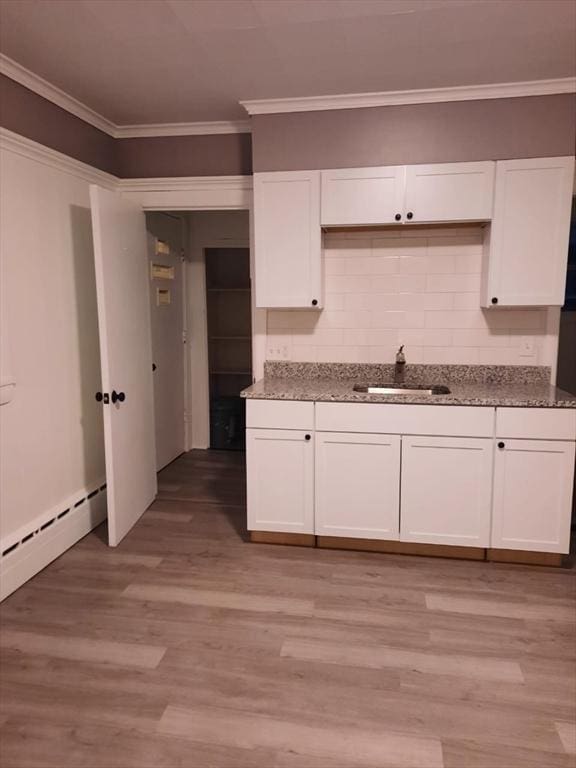 kitchen featuring stone counters, white cabinetry, sink, and ornamental molding