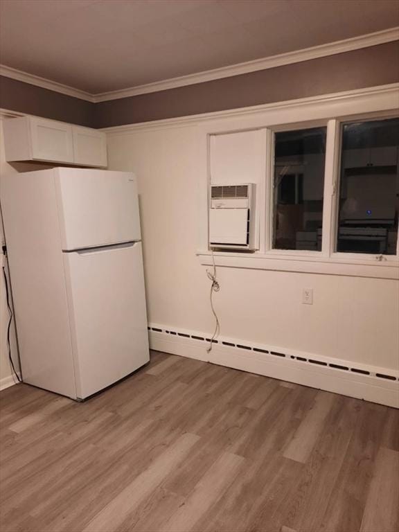 kitchen with white cabinetry, crown molding, light hardwood / wood-style floors, and white fridge