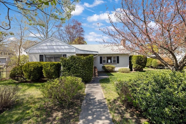 view of front of house with a front yard, fence, and a chimney