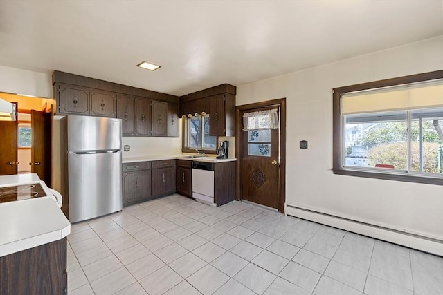 kitchen featuring light tile patterned floors, light countertops, dishwasher, freestanding refrigerator, and a baseboard radiator
