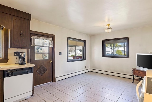 kitchen featuring light tile patterned floors, light countertops, dark brown cabinets, a baseboard heating unit, and white dishwasher