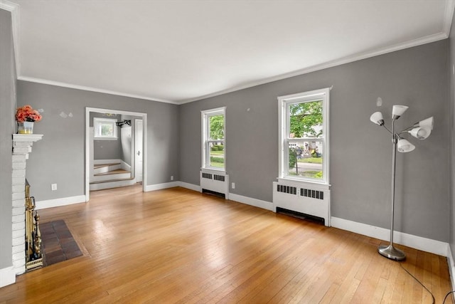 229 May St, Worcester, MA 01602 - unfurnished living room featuring radiator, ornamental molding, light wood-type flooring, baseboards, and stairway