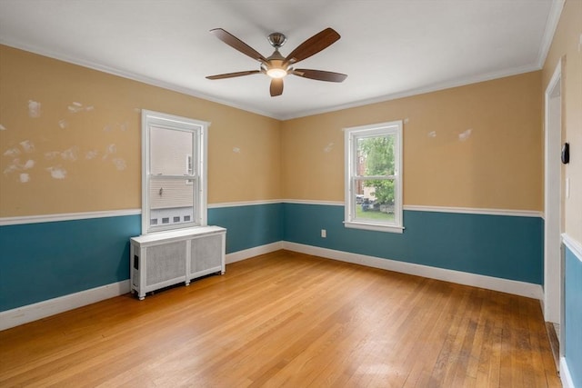 229 May St, Worcester, MA 01602 - empty room with radiator heating unit, a ceiling fan, light wood finished floors, baseboards, and crown molding