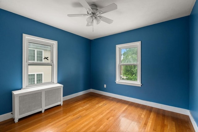 229 May St, Worcester, MA 01602 - spare room featuring radiator heating unit, baseboards, light wood finished floors, and a ceiling fan
