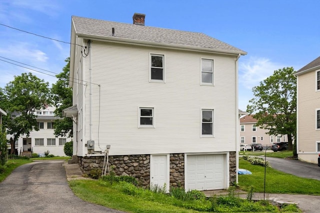 229 May St, Worcester, MA 01602 - view of home's exterior with a chimney, a garage, stone siding, and driveway