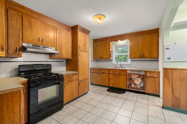 229 May St, Worcester, MA 01602 - kitchen with black gas range oven, under cabinet range hood, dishwasher, brown cabinets, and a sink