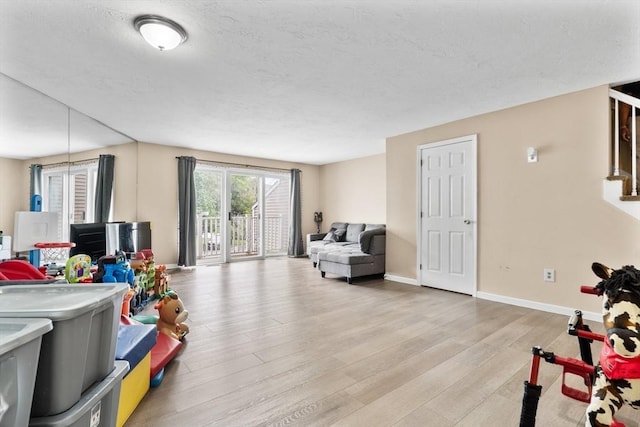 7 Hovey Pond Dr Unit 7, Grafton, MA 01536 - rec room with light wood-type flooring, baseboards, and a textured ceiling