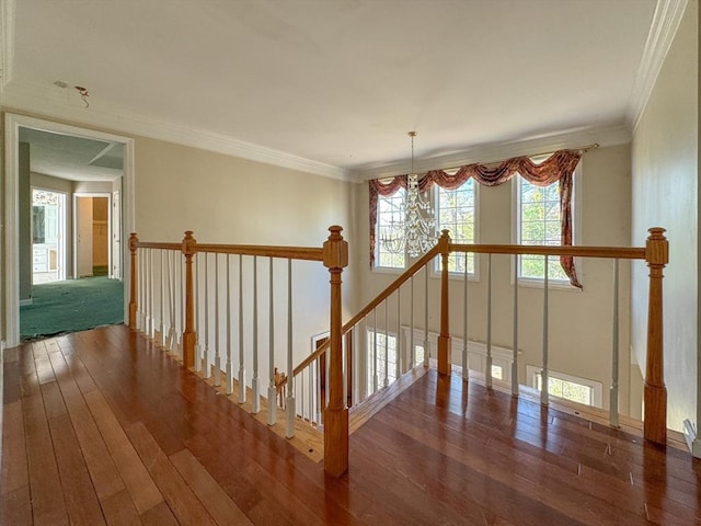 stairway with ornamental molding, hardwood / wood-style flooring, and a chandelier