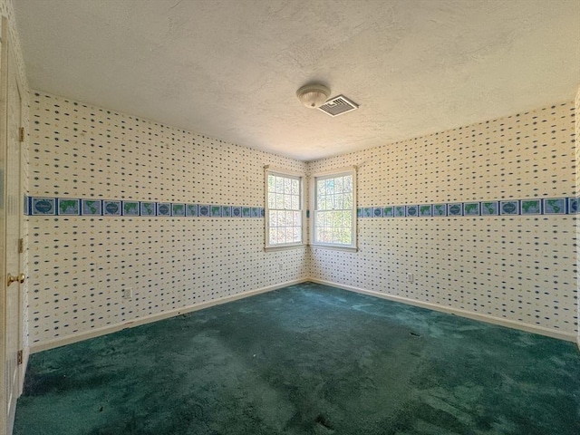 empty room featuring a textured ceiling, visible vents, baseboards, and carpet floors