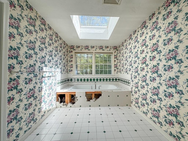 full bathroom with tile patterned floors, wallpapered walls, a skylight, and a bath