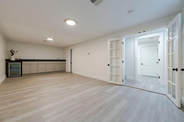 74 Dedham St, Newton, MA 02461 - basement featuring french doors, wine cooler, light wood-style flooring, and a dry bar
