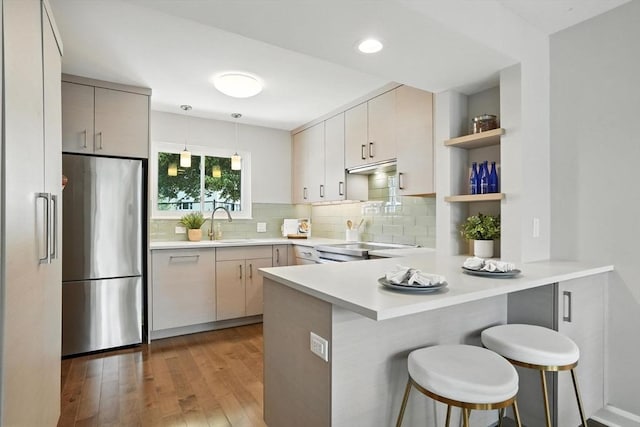 109 Governor Winthrop Rd Unit 109, Somerville, MA 02145 - kitchen featuring stainless steel refrigerator, a peninsula, decorative backsplash, light wood-type flooring, and open shelves