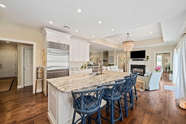 31 Chittenden Ln Unit 31, Cohasset, MA 02025 - kitchen with dark wood-type flooring, stainless steel built in refrigerator, white cabinetry, light stone counters, and crown molding