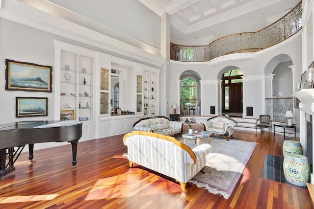 11 Fairway Dr, Andover, MA 01810 - living room with a high ceiling, ornate columns, arched walkways, wood finished floors, and built in shelves