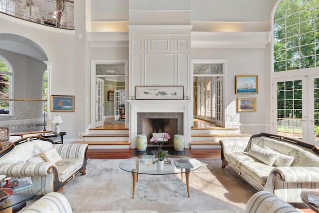 11 Fairway Dr, Andover, MA 01810 - living area featuring a fireplace with flush hearth, a high ceiling, crown molding, wood finished floors, and french doors